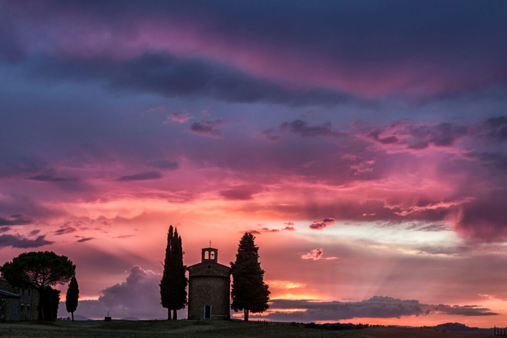 Sunset over Val d’Orcia cappella di vitaleta hills near Villa Montelandi Tuscany landscape view