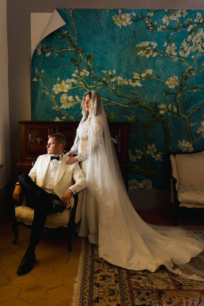 Elegant wedding portrait at Villa Montelandi, with the couple posed in front of a blue floral mural inspired by Van Gogh.